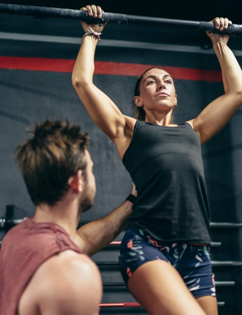 Coach helping a woman in a gym